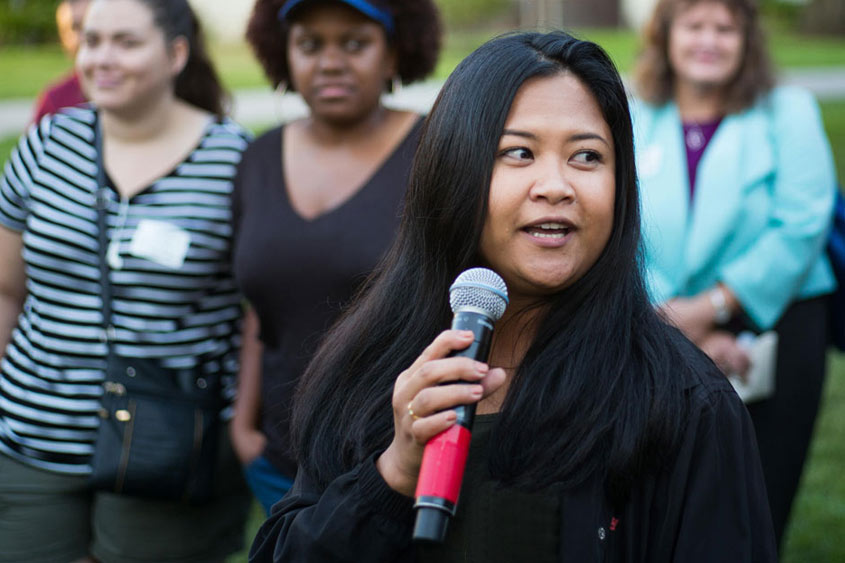 九州体育 community member holding a mic and talking.